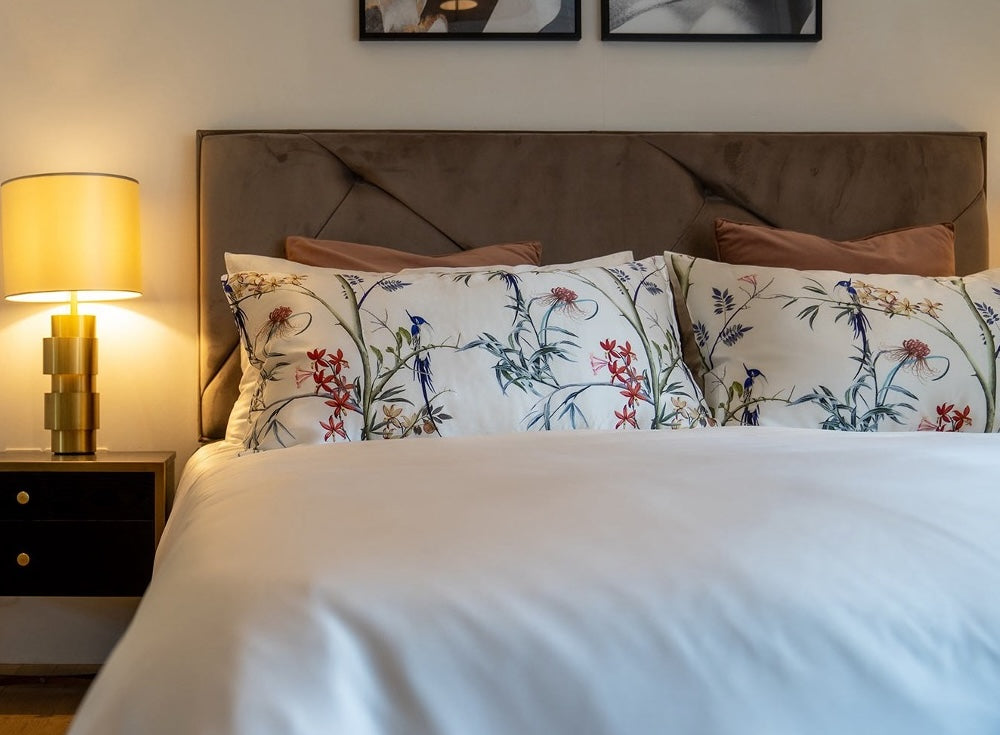 Pillows covered in Mayfairsilk Hummingbird Pure Silk Pillowcases, lined up neatly by the bed header