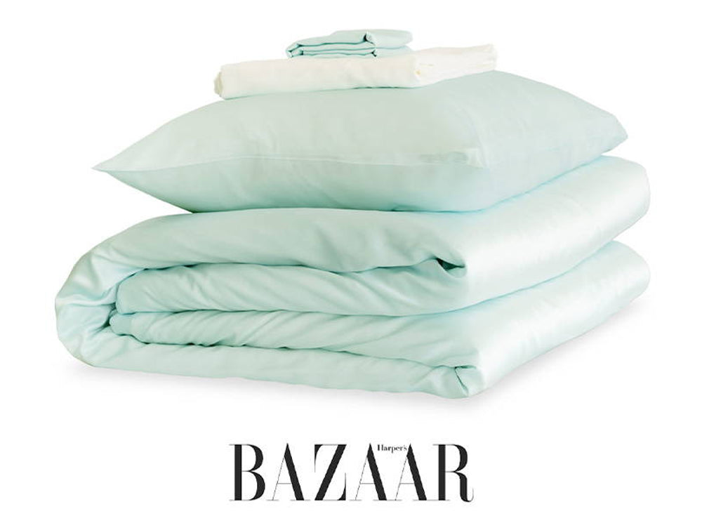 Folded pale blue silk bedding with Harper's Bazaar artwork