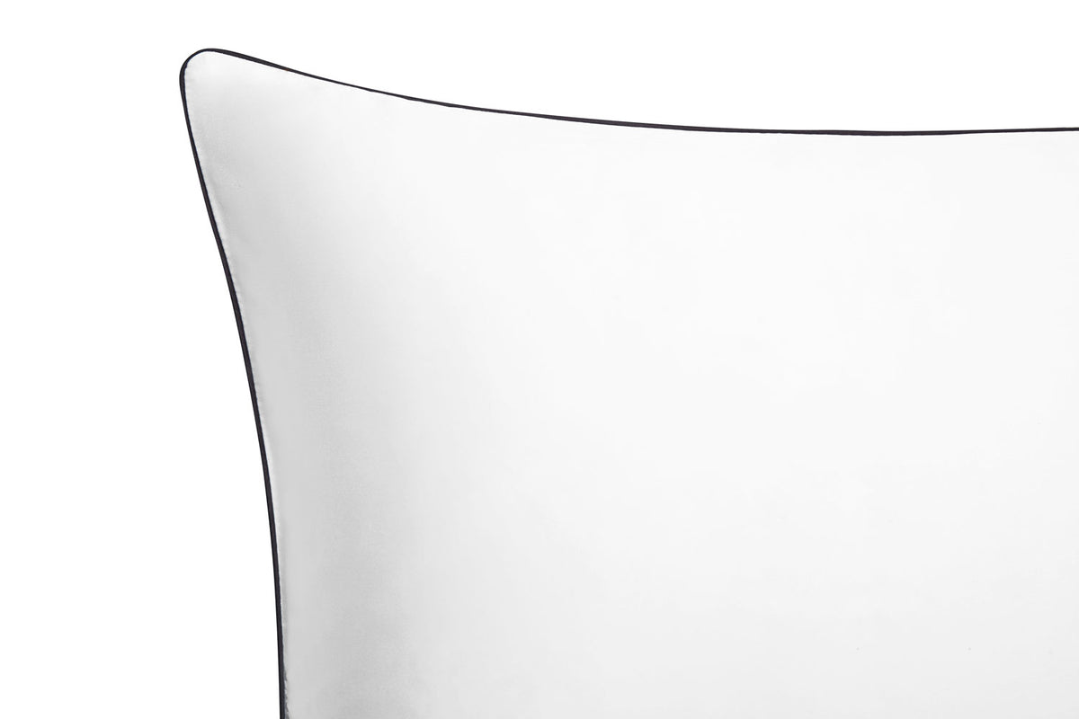 Closeup of Brilliant White silk pillowcase with charcoal piping on the border