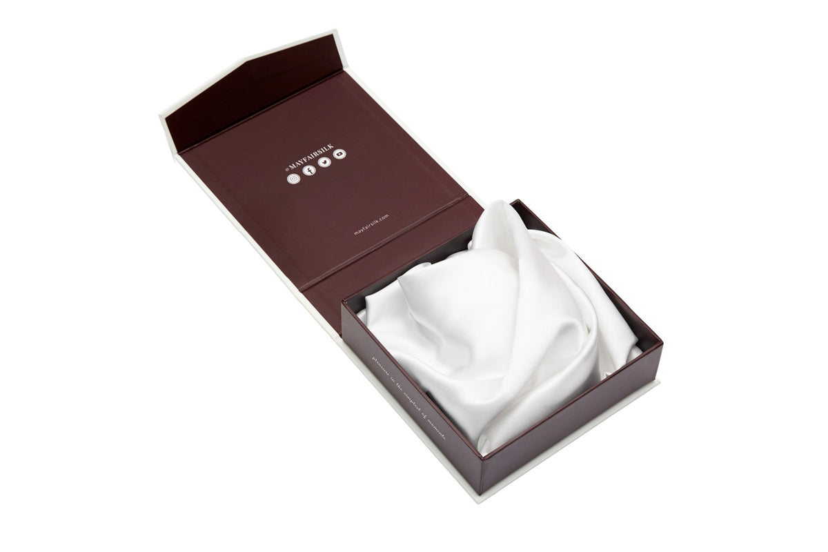 White silk pillowcase folded like a flower inside an open luxury gift box by Mayfairsilk
