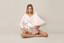 Load image into Gallery viewer, girl sitting holding a beautiful soft pink silk pillowcase and cushion with hummingbird and foliage by Mayfairsilk