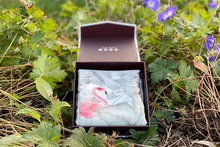 Load image into Gallery viewer, Flamingos silk pillowcase folded and displayed in an open gift box sitting on fresh green leaves and purple flowers