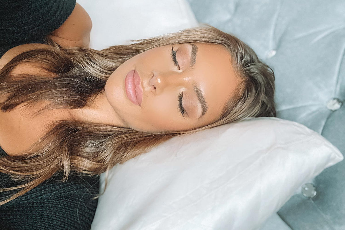 pretty girl sleeping on silk pillowcase with luxury velvet bedhead