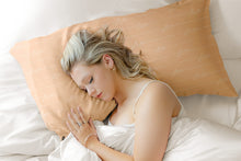 Cargar imagen en el visor de la galería, Girl Sleeping on Love Silk Pillowcase finished in Peach Fuzz colour tone
