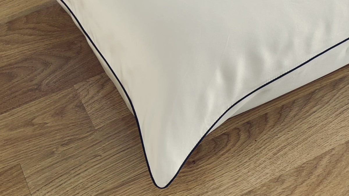 Short clip closeup of ivory pillowcase with charcoal piping