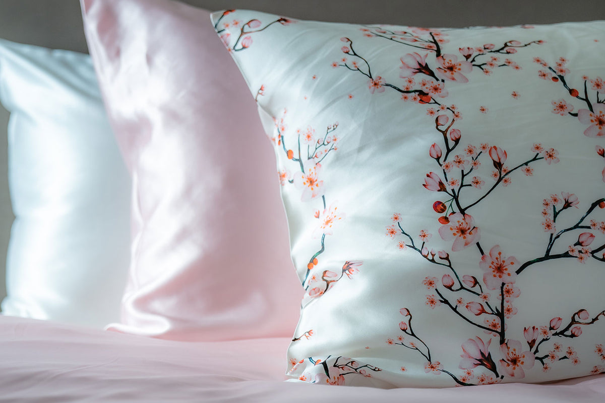 Three silk pillowcases by Mayfairsilk, in the foreground is Cherry Blossom, followed by Precious Pink and White at the back